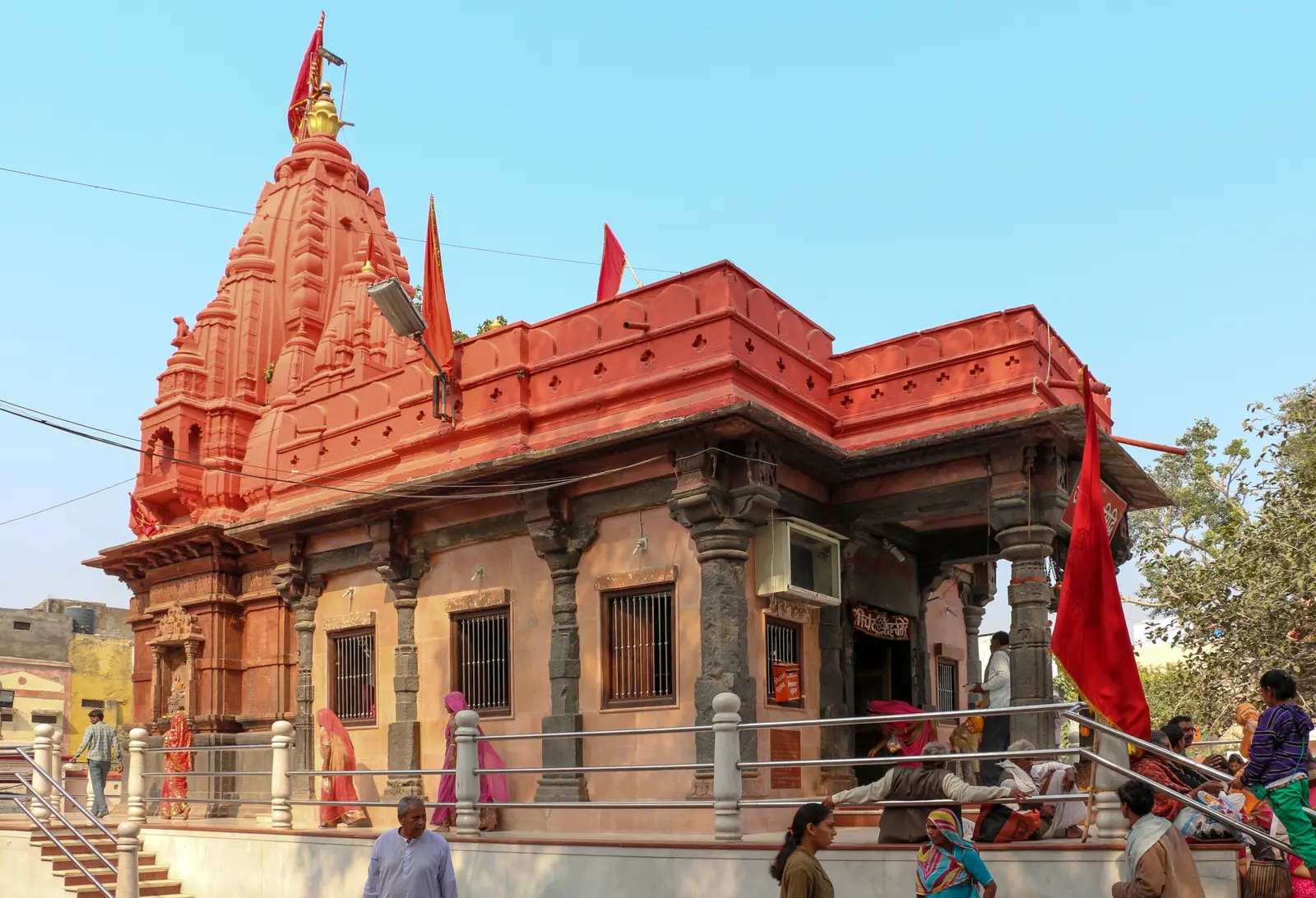 शिखर और स्तंभों वाले मंडप के साथ हरसिद्धि माता का लाल रंग का मंदिर