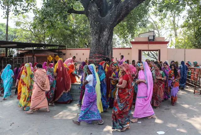 मंदिर परिसर में पवित्र वृक्ष के चारों ओर महिला श्रद्धालु